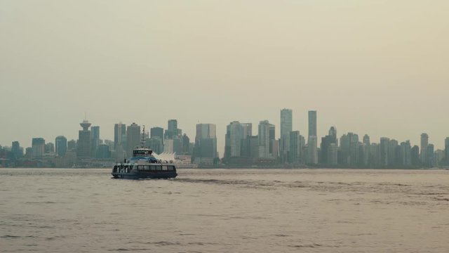 Sea bus sailing towards Vancouver downtown on cloudy day