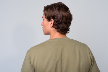 Young handsome man with wavy hair against white background