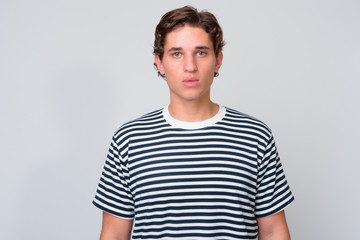 Fototapeta premium Young handsome man with wavy hair against white background