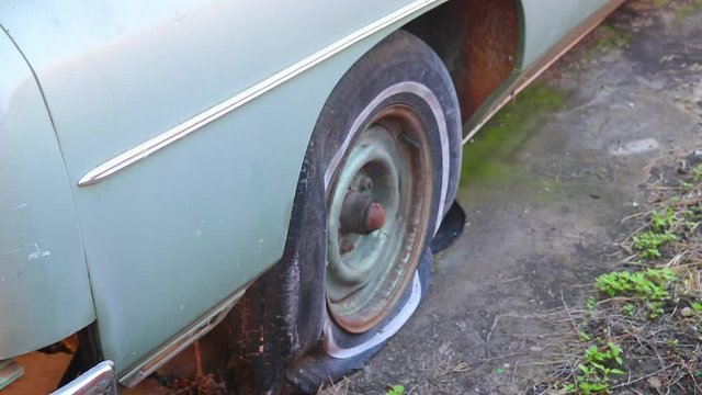Vintage chevrolet impala with 350 motor in Waco Texas USA, steady handheld side close up of flat tyre