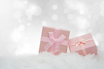 Pink gift boxes on the snowfall with copy space for season greeting Merry Christmas or Happy New Year