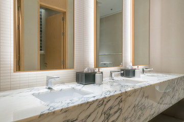 Interior of bathroom with washbasin faucet and black towel in hotel. Modern design of bathroom.