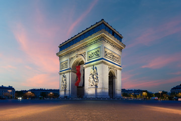 Plakat Arc de Triomphe Paris and Champs Elysees with a large France flag flying under the arch in Europe victory day at Paris, France.