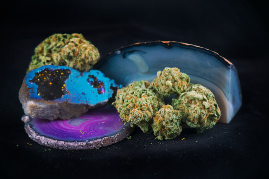 Dried cannabis nugs isolated on black background with geodes and agate crystal