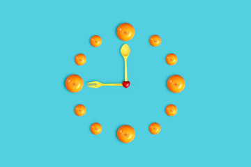 wall clock with orange, heart symbol, fork and spoon on blue pastel background