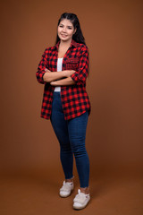 Studio portrait of young beautiful Asian woman smiling