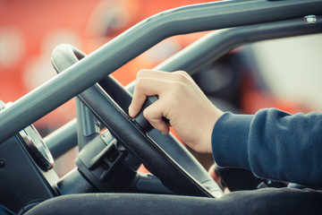 Man operating steering wheel in agricultural or industrial machine, detail of vehicle