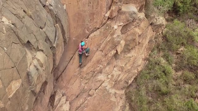 Drone shot on a female climber while she&sbquo;&Auml;&ocirc;s climbing, revealing the cliff and the vegetation.Location : Tenerife, Canary Island, Spain