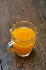 Glass of orange juice on wooden table