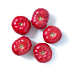 Fresh red tomatoes laid out in the shape of a Pentagon, isolated on white background