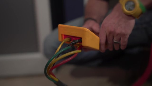 A technician uses a handheld industrial testing device.