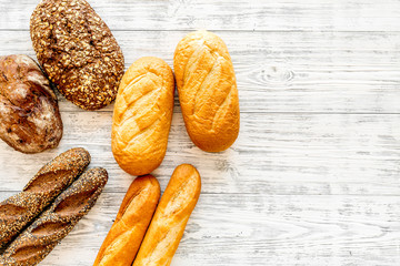 Fresh rustic homemade bread on white wooden background top view copy space