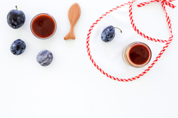 Fruit puree for small babies. Puree with prunes in bowl near punes, spoon, bib on white background top view copy space
