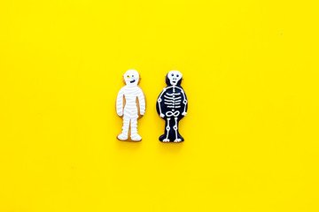 Fototapeta premium Halloween traditions. Halloween gingerbread in shape of evil characters on yellow background top view space for text