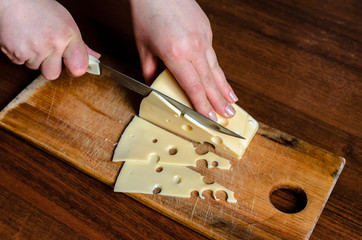 Slicing cheese on a wooden board.