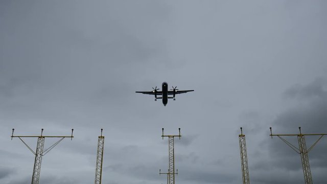 Propellor plane flying over approach lights