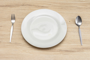 Close up setting of White plate on the wooden table.