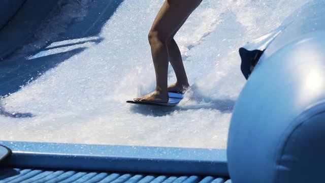 Surfing wave machine slow motion, close up on feet