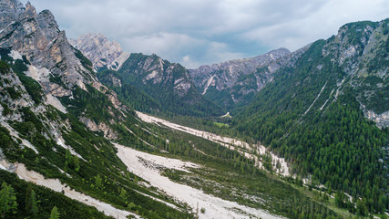 Fototapeta na wymiar Aerial view of the mudflow with snow high in the Alpine mountains