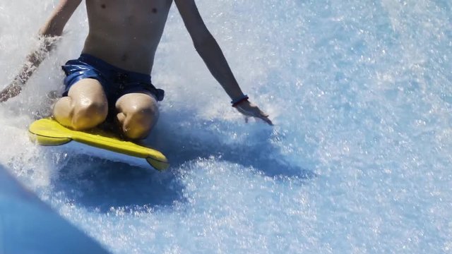 Boy riding wave machine on boogie board