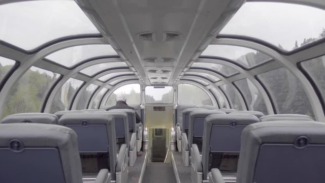 4K interior of a passenger train dome car travelling through a forest