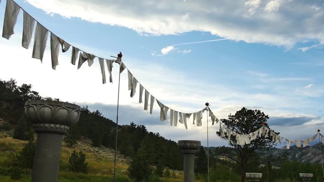 White prayer flags blowing in the breeze as the sun goes down at the stupa in Red Feather Lakes, CO