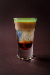 Hiroshima alcoholic shot glass with absent, sambuca, irish cream on elegant dark brown background