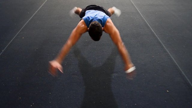 a guy doing a special kind of push up
in a top/side/front view still shot
inside a gymnastics gym