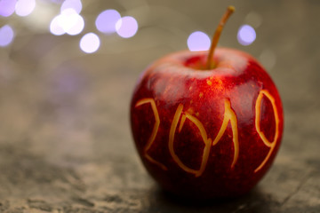On an brown background is an apple with the inscription numbers 2019. There are lights in the background. The concept of celebrating the New Year. Background, blurred, close-up