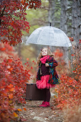 Cute little girl playing with fallen golden leaves. Happy child walking in autumn park.  Cute girl...