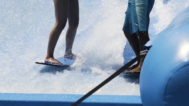 Instructor helping a girl surf on a wave machine, CLOSE UP