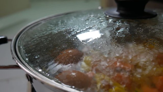 Egg and vegetables boiled in boiling water on aluminum pot.