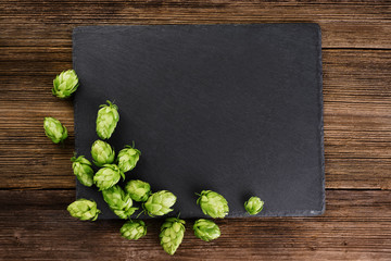 Hops on wooden background and slate board background.