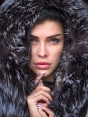 Young woman in a snowy furry hood.