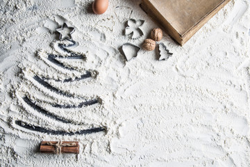 Shaped christmas tree of flour and old recipe book.