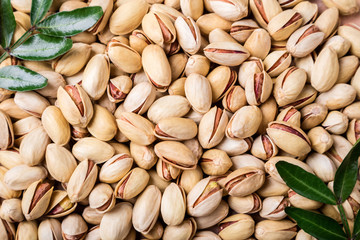 Pistachios nuts background. Pistachio texture with leaves. Nuts. Top view
