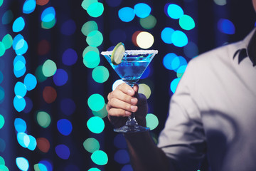 Blue margarita in hand of party guest