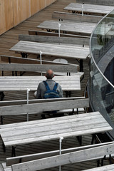 ein mann sitzt allein an einem tisch auf der nebelhorn-sonnenterrasse