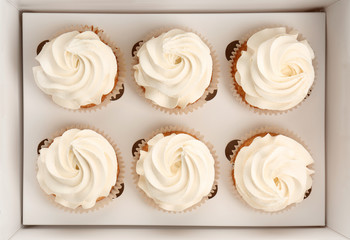 Box with delicious cupcakes, top view