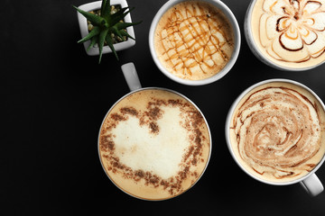 Cups with tasty aromatic coffee on black background, flat lay