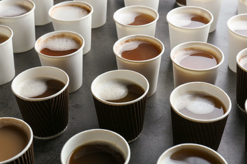 Many plastic cups with tasty aromatic coffee on table