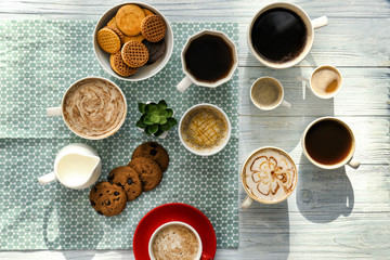 Obraz na płótnie Canvas Flat lay composition with cups of tasty aromatic coffee and cookies on wooden background