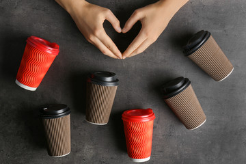 Female hands and many plastic cups of coffee on grey background, top view