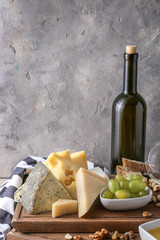 Bottle of wine with snacks and ripe grapes on table