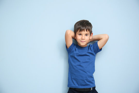 Cute little boy in t-shirt on color background