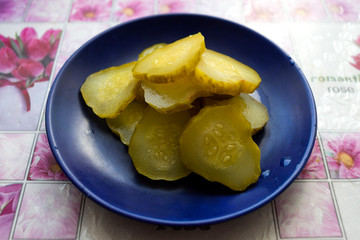 pickled cucumbers on a blue saucer