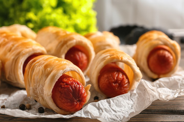 Freshly baked tasty sausage rolls on table, closeup