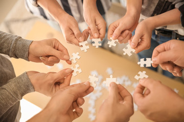 Group of people holding pieces of puzzle