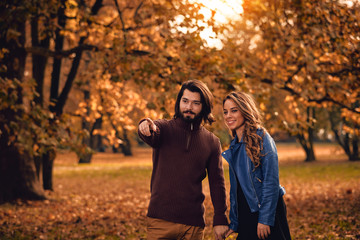 Couple in autumn season colored park enjoying outdoors.