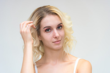 Fototapeta premium Beauty portrait of a beautiful blonde girl on a white background with perfect makeup.